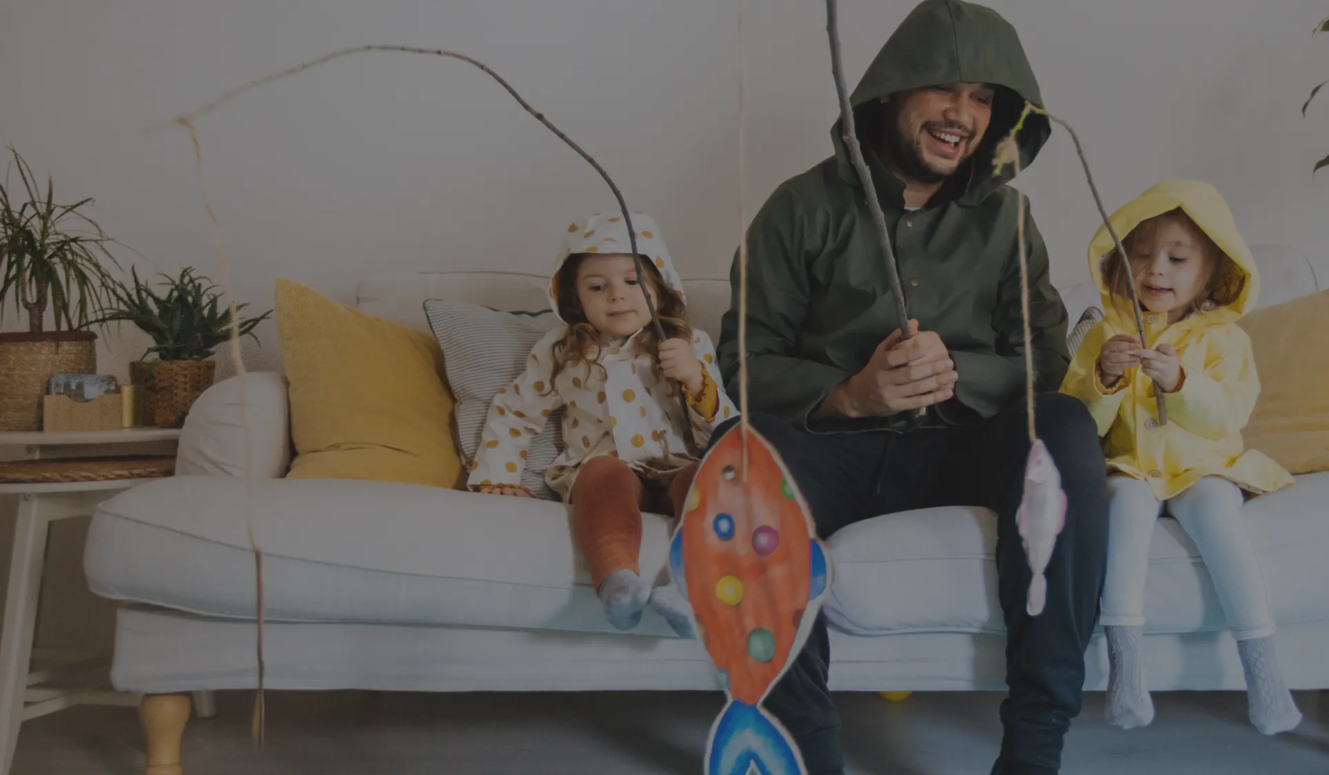 A father plays fishing at home with his two daughters.